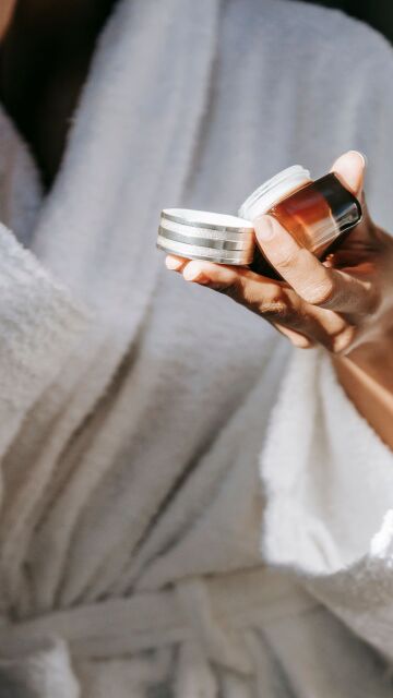 Mujer con un cosm&eacute;tico en la mano
