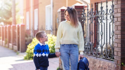 Mujer llevando a su hijo a la escuela