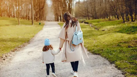 Mujer llevando a su hija a la escuela Mujer llevando a su hija a la escuela