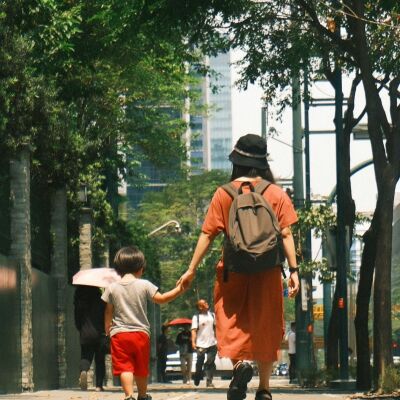 Mujer llevando a su hijo a la escuela