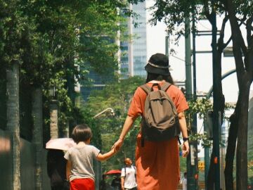 Mujer llevando a su hijo a la escuela