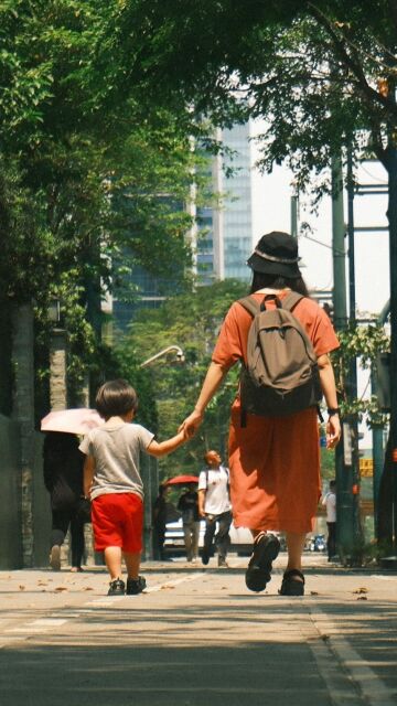 Mujer llevando a su hijo a la escuela