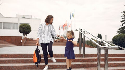 Mujer llevando a su hija a la escuela