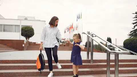 Mujer llevando a su hija a la escuela Mujer llevando a su hija a la escuela