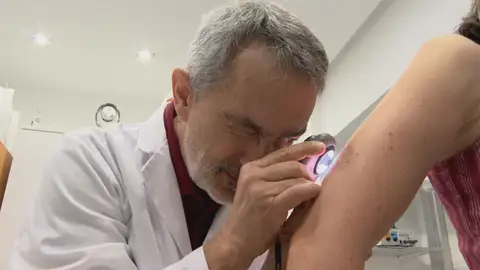 Imagen de un dermatólogo observando un lunar Imagen de un dermatólogo observando un lunar