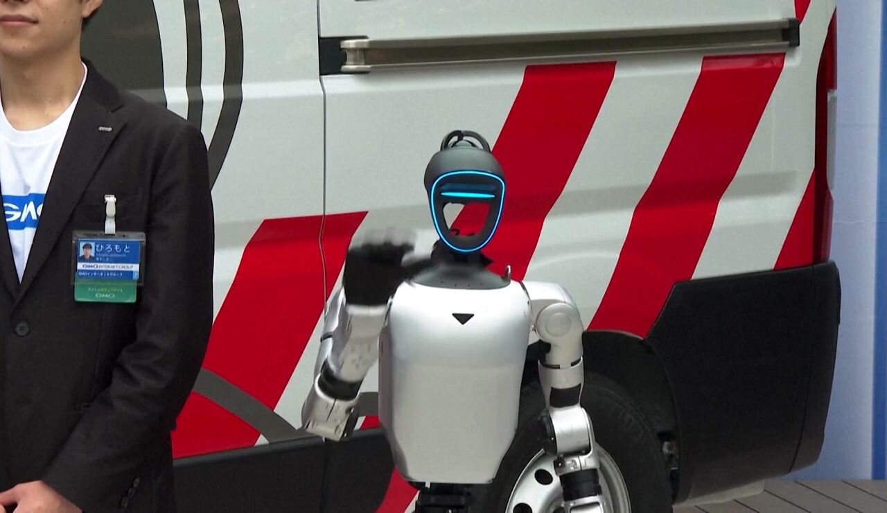Un robot posa junto a la ambulancia de robots humanoides japonesa.