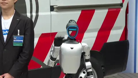 Un robot posa junto a la ambulancia de robots humanoides japonesa. Un robot posa junto a la ambulancia de robots humanoides japonesa.