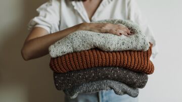 Una mujer sujetando cuatro jers&eacute;is