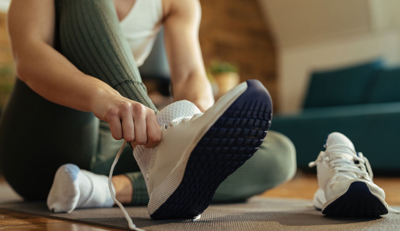 Mujer poni&eacute;ndose unas zapatillas deportivas