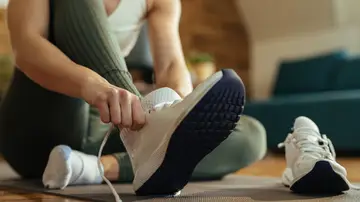Mujer poniéndose unas zapatillas deportivas Mujer poniéndose unas zapatillas deportivas