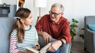 Abuelo y nieta leyendo un libro