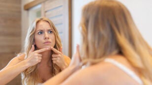Mujer toc&aacute;ndose un grano
