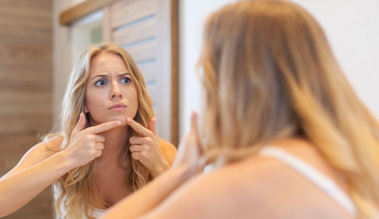Mujer toc&aacute;ndose un grano