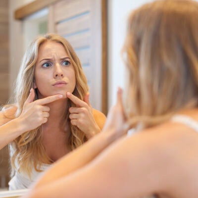 Mujer toc&aacute;ndose un grano