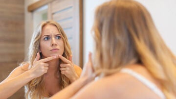 Mujer toc&aacute;ndose un grano
