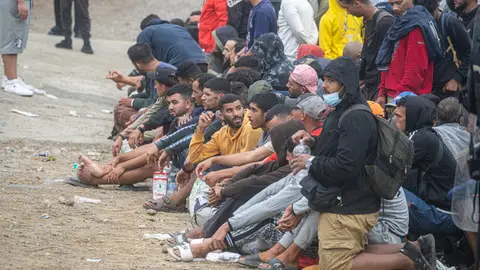 Los migrantes desalojados del Trampolín se dividen entre los que regresan a Marruecos y los que prefieren filiarse Numerosos migrantes durante el proceso de desalojo del embolsamiento de migrantes en la playa de El Trampolín, a 4 de octubre de 2026, en Ceuta (España). La Policía Nacional escolta los autobuses llenos de personas migrantes desalojadas de la playa del Trampolín hacia la zona de la frontera del Tarajal, donde unos optan por quedarse en el Centro de Atención Temporal para Extranjeros (CATE) al objeto de ser filiados y posteriormente acogidos y otros prefieren regresar a Marruecos a pie y volun...