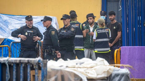 Agentes de la Polic&iacute;a Nacional intervienen durante el proceso de desalojo del embolsamiento de migrantes en la playa de El Trampol&iacute;n, a 4 de octubre de 2026, en Ceuta (Espa&ntilde;a). La Polic&iacute;a Nacional escolta los autobuses llenos de personas migrantes desalojadas de la playa del Trampol&iacute;n hacia la zona de la frontera del Tarajal, donde unos optan por quedarse en el Centro de Atenci&oacute;n Temporal para Extranjeros (CATE) al objeto de ser filiados y posteriormente acogidos y otros prefieren regresar a ...