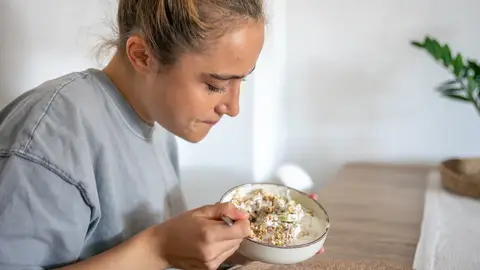 Mujer comiendo avena con yogur Mujer comiendo avena con yogur