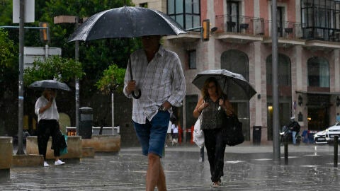 Personas protegi&eacute;ndose de la lluvia