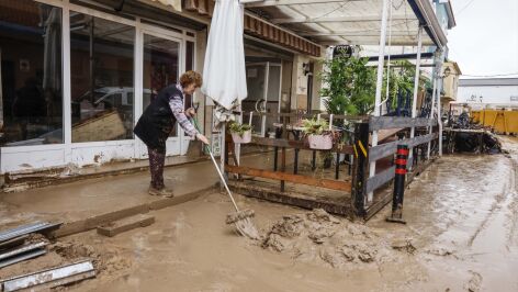 Una mujer limpiando los estragos de Adam