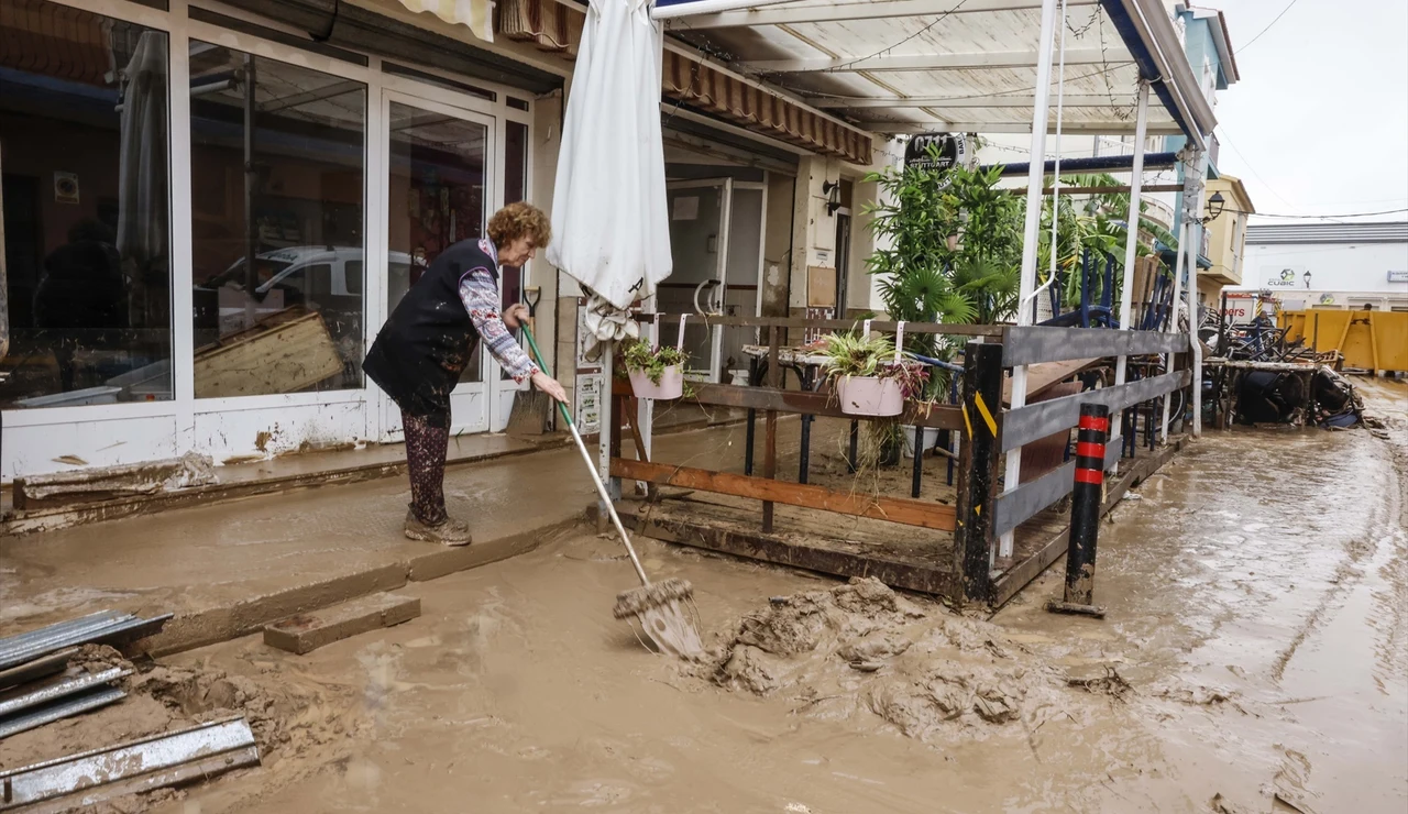 Una mujer limpiando los estragos de Adam