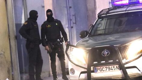 Dos agentes de la Guardia Civil junto al veh&iacute;culo policial