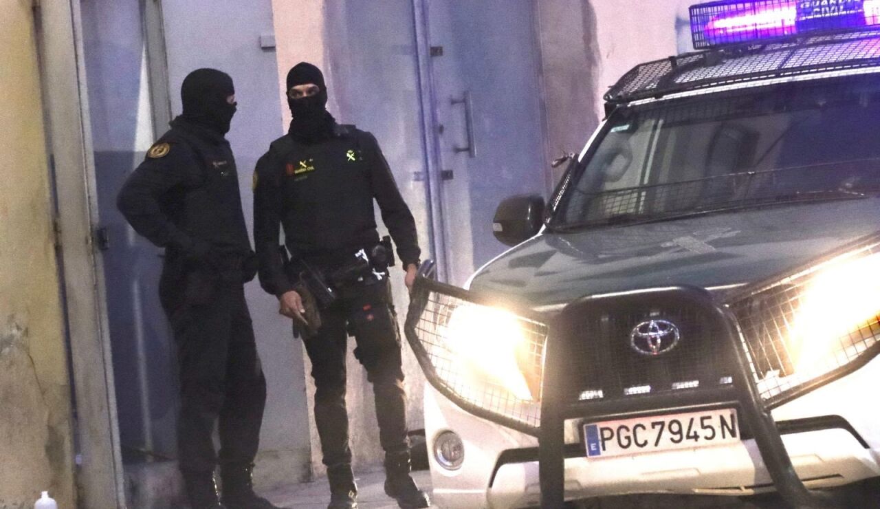 Dos agentes de la Guardia Civil junto al veh&iacute;culo policial