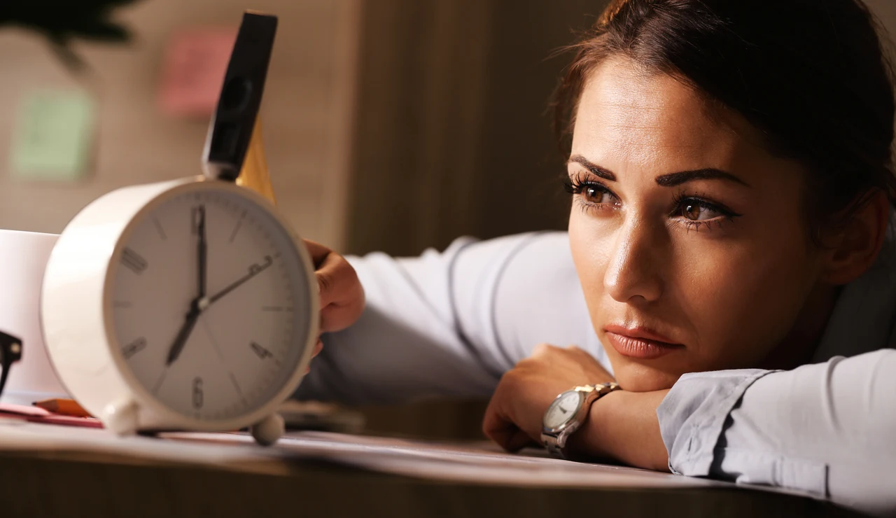 Mujer cansada mirando al reloj
