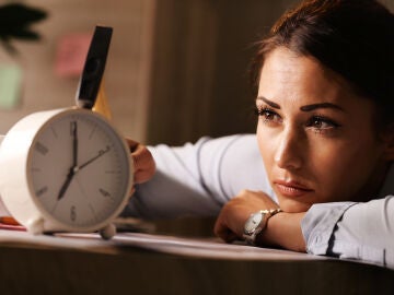 Mujer cansada mirando al reloj