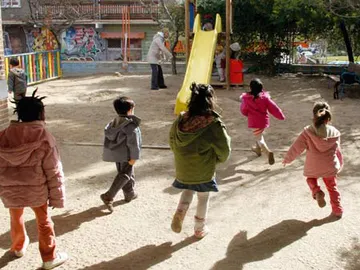 Varios niños salen a jugar a un parque infantil Varios niños salen a jugar a un parque infantil