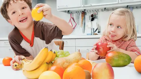 Dos niños comiendo fruta Dos niños comiendo fruta