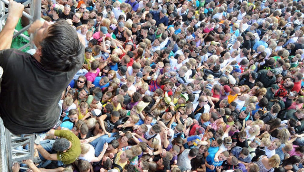 Un joven sube por una escalera improvisada en el Love Parade