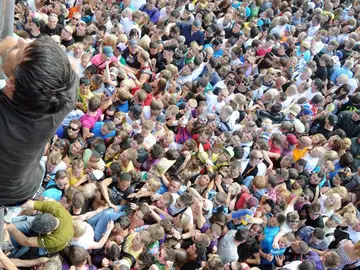 Un joven sube por una escalera improvisada en el Love Parade Un joven sube por una escalera improvisada en el Love Parade
