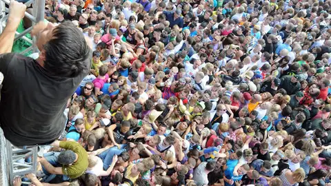Un joven sube por una escalera improvisada en el Love Parade Un joven sube por una escalera improvisada en el Love Parade