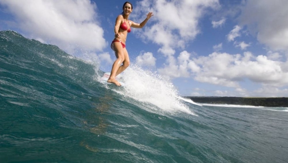 Una chica surfeando una ola