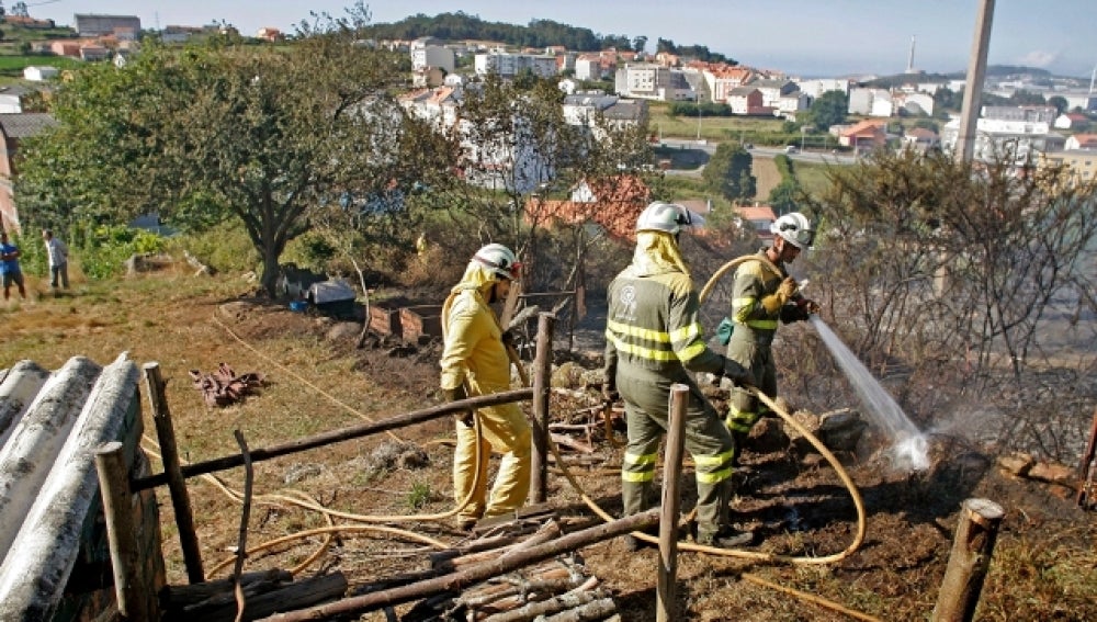 Trabajos de extinción de un incendio en Outes