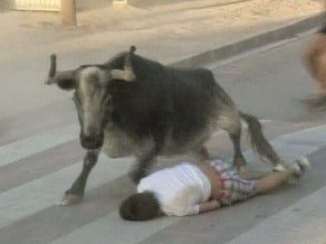 Un joven tumbado en el suelo al paso de un toro