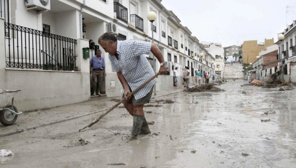 Un vecino fregando el barro de la riada