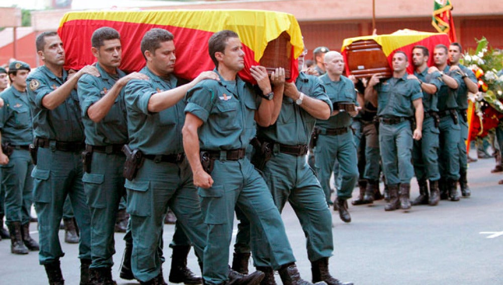 Los compañeros de los guardias civiles portan sus féretros