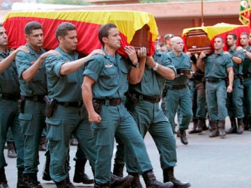 Los compañeros de los guardias civiles portan sus féretros