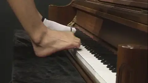 Pianista chino toca con los pies Pianista chino toca con los pies