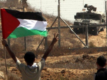 Ondea una bandera palestina ante las tropas israelíes