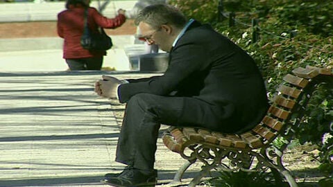 Un hombre medita en un banco