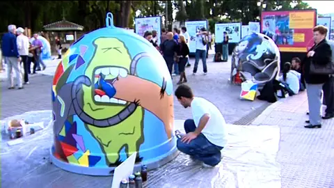 Un joven hace un graffiti en un contenedor Un joven hace un graffiti en un contenedor