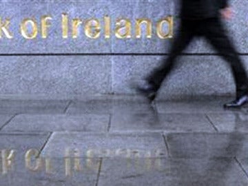 Un hombre pasa frente a la fachada del Banco de Irlanda