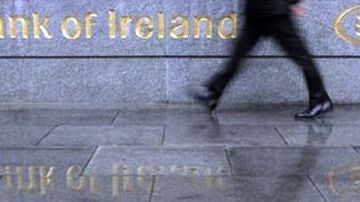 Un hombre pasa frente a la fachada del Banco de Irlanda