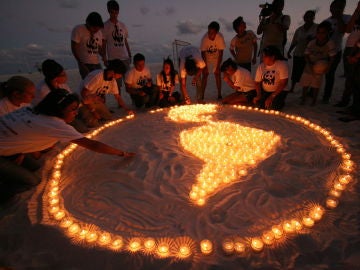 Dibujan Sudamérica con velas en la playa de Cancún