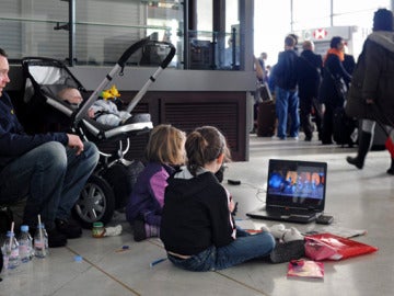 Dos niños esperan junto a sus padres en el aeropuerto Charles de Gaulle, París