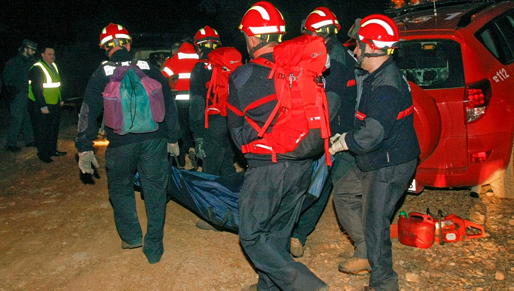 Los bomberos trasladan el cuerpo de uno de los cazadores