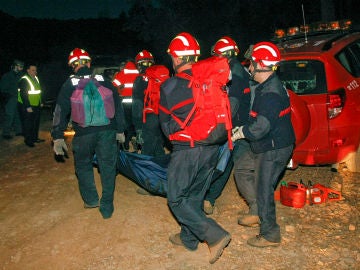 Los bomberos trasladan el cuerpo de uno de los cazadores